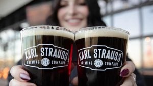 two glasses of beer holding by a woman